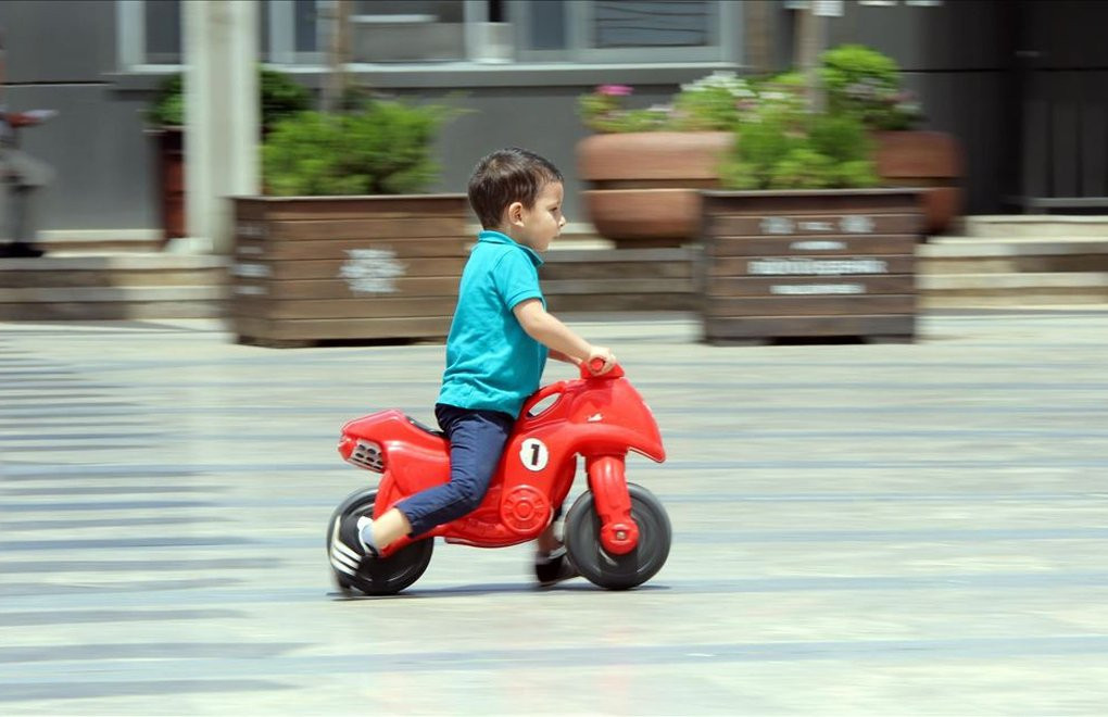 kırmızı Oyuncak motorsiklete binen çocuk